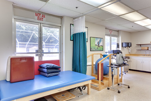 A well-equipped physical therapy room featuring exercise equipment and treatment areas.