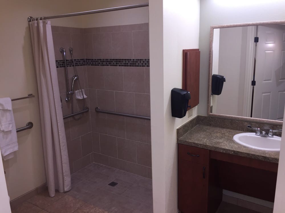 Accessible bathroom with a shower and sink area.