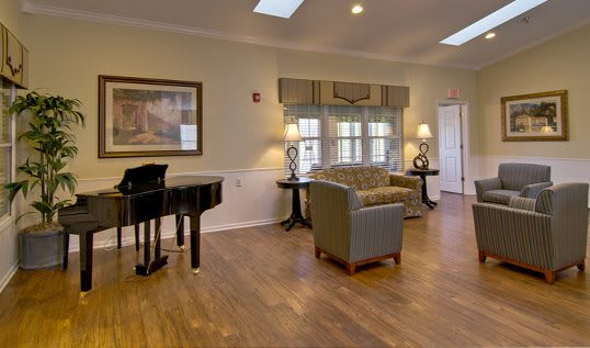 A cozy living room with a grand piano and comfortable seating.