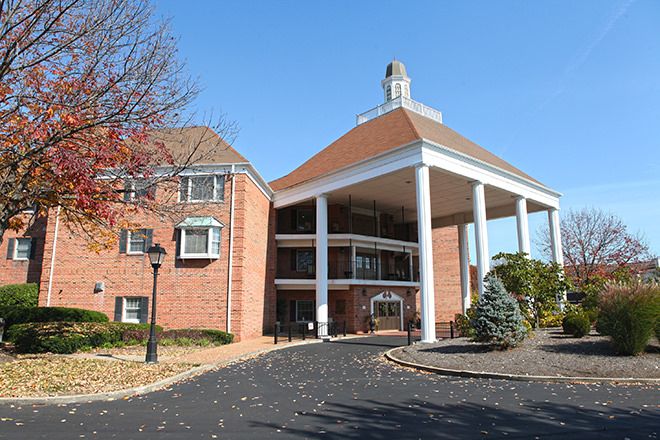 A brick building with large columns at the entrance under a clear blue sky.