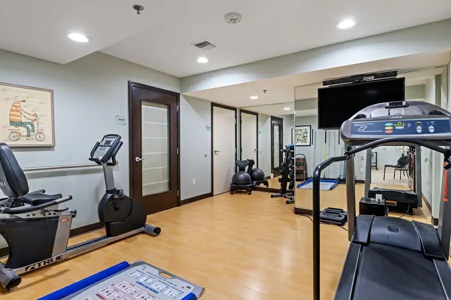 A well-equipped home gym with exercise machines and mirrors.