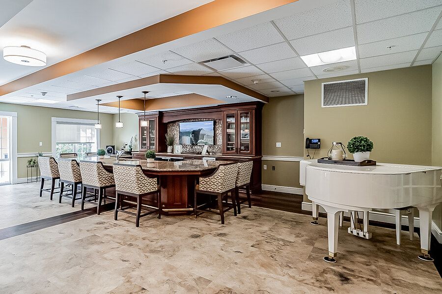A cozy lounge area featuring a bar, piano, and comfortable seating.