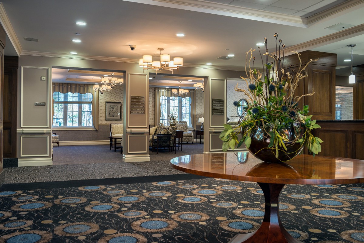 An elegantly decorated lobby with chandeliers and floral arrangements.