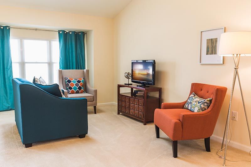 A cozy living room with colorful furniture and a television.