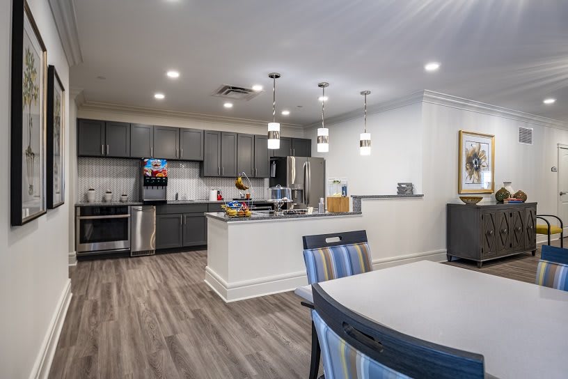 A modern kitchen with an open dining area featuring sleek appliances and stylish lighting.