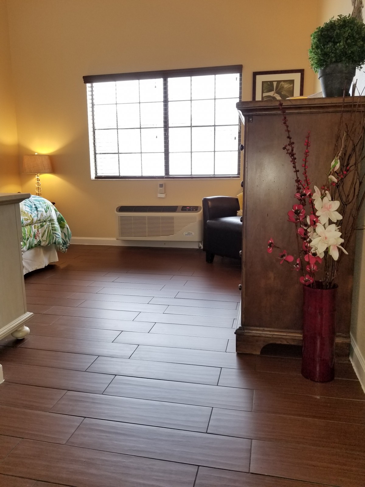 A cozy bedroom with wooden flooring and elegant decor.