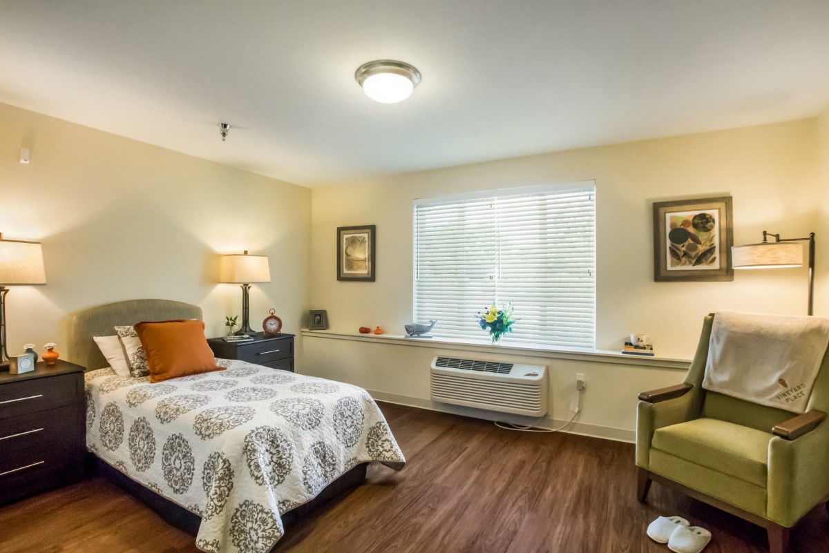 A cozy bedroom with a single bed, warm lighting, and tasteful decor.