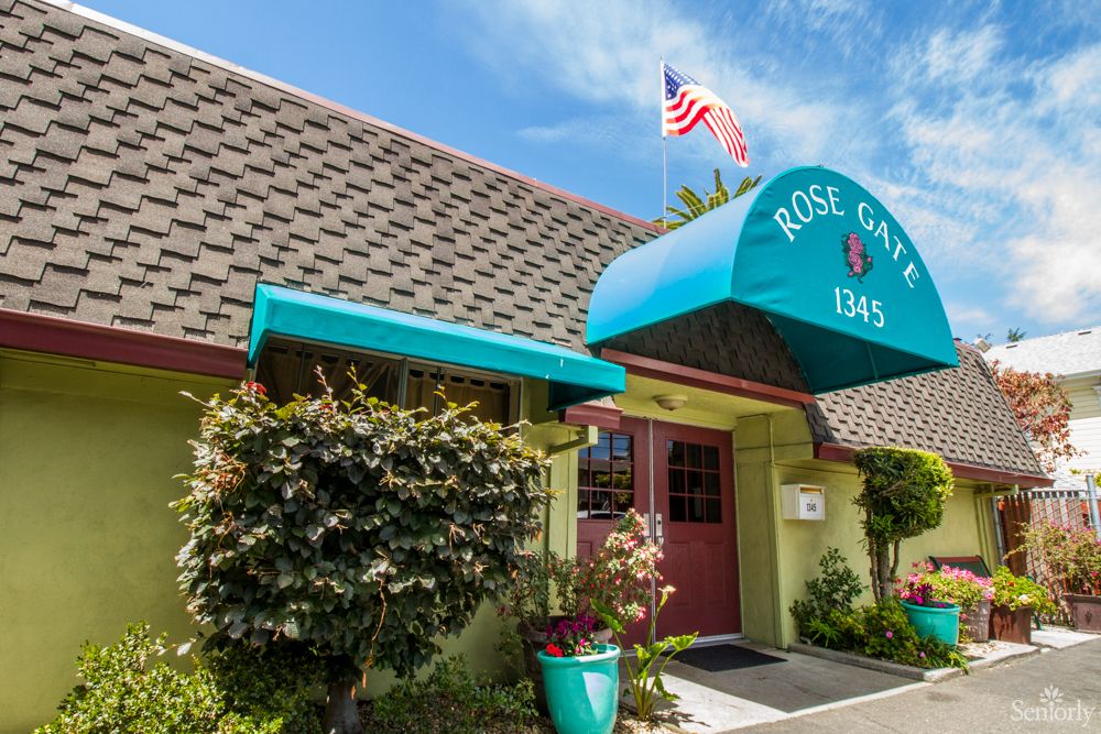 The entrance of a cozy inn with an American flag and vibrant signage on a clear day.
