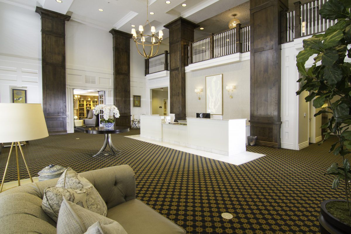 A spacious hotel lobby featuring a modern reception desk and elegant furnishings.