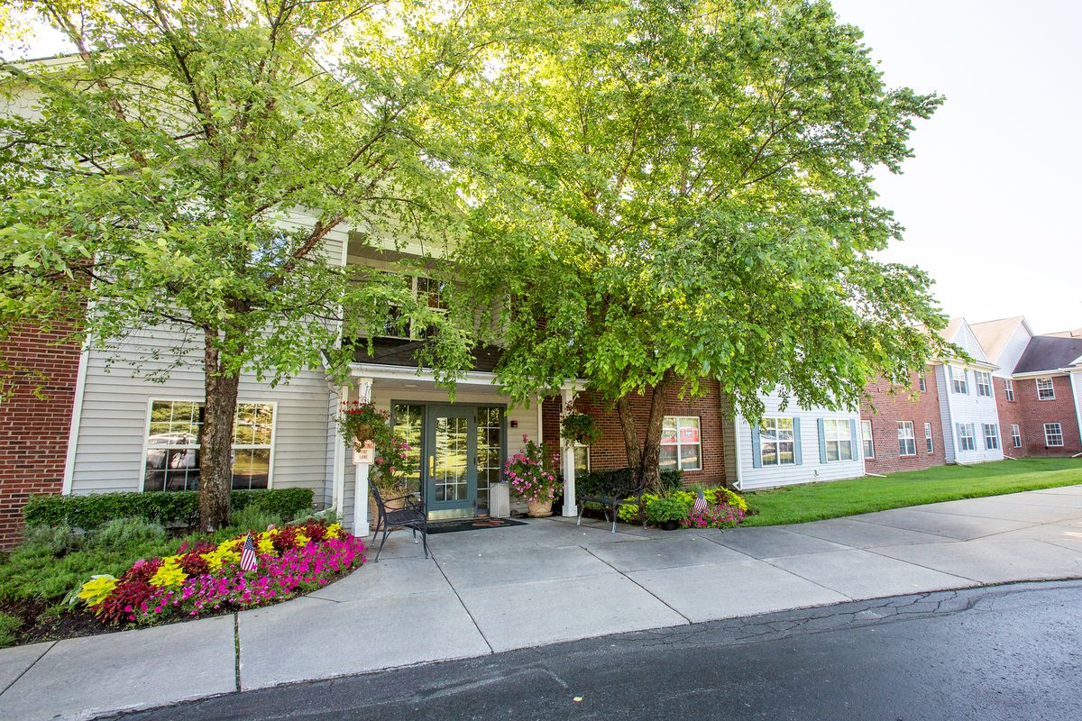 A welcoming entrance surrounded by lush trees and colorful flowers.
