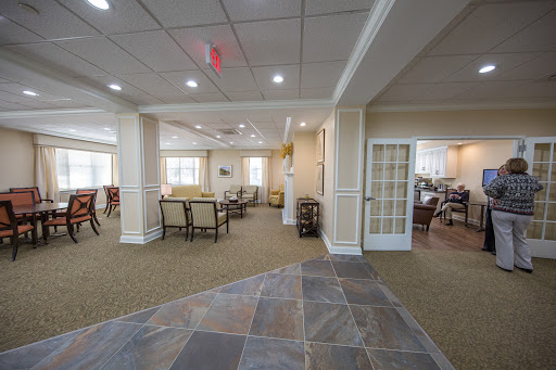 A spacious and well-lit common area in a residential facility, featuring comfortable seating arrangements and a welcoming atmosphere.