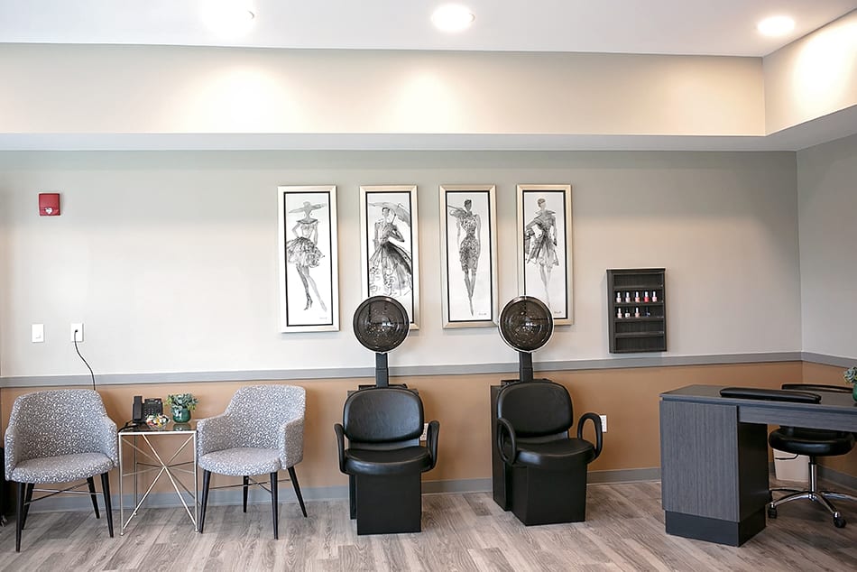 A chic salon interior featuring stylish artwork and seating with hair dryers.