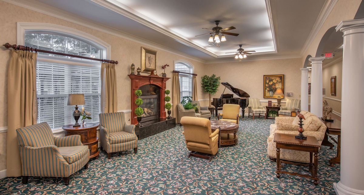 A cozy living room with elegant furnishings, featuring a fireplace and a grand piano.