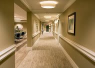 A well-lit corridor with carpeted flooring in an office building.