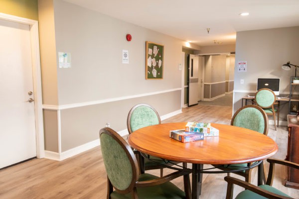A cozy dining area with a round table and chairs in a well-lit hallway.