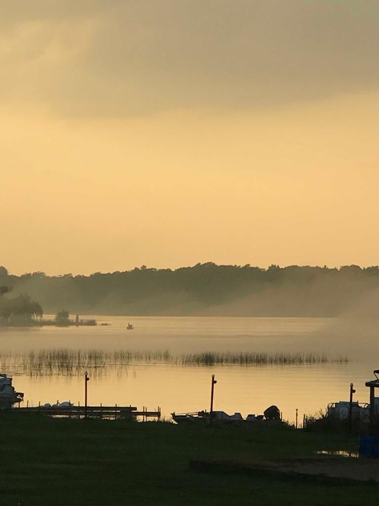 A serene view of a misty lake at sunset.