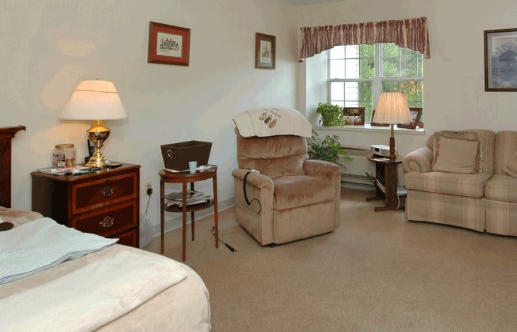 A cozy living room with armchairs, a side table, and decorative lamps.