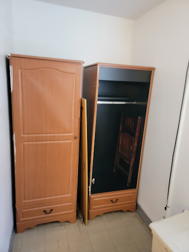 Two wooden wardrobes in a minimalistic bedroom setting.