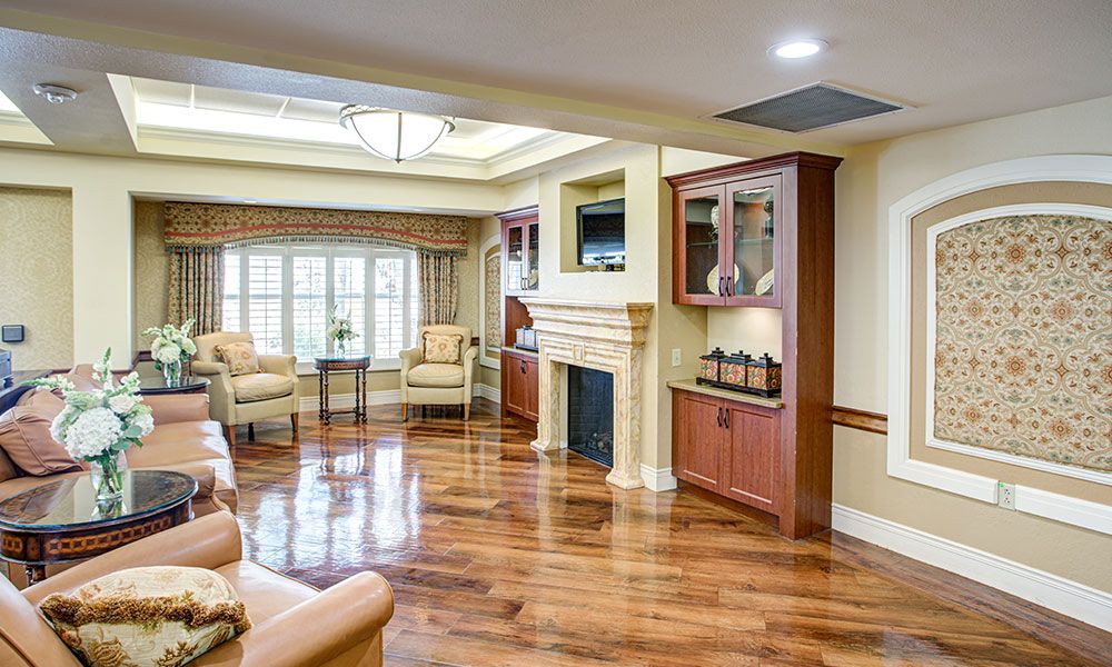 A spacious living room with hardwood floors, a fireplace, and comfortable seating.