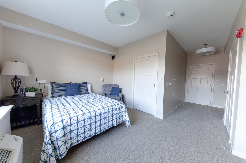 A minimalist bedroom with a neatly made bed and simple decor.