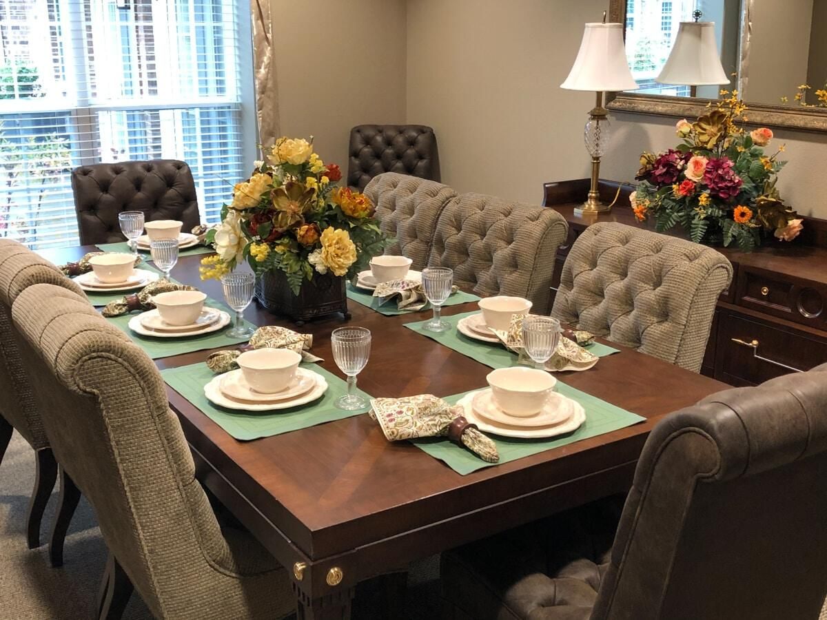 A beautifully arranged dining table with elegant dinnerware and floral centerpieces in a cozy dining room.