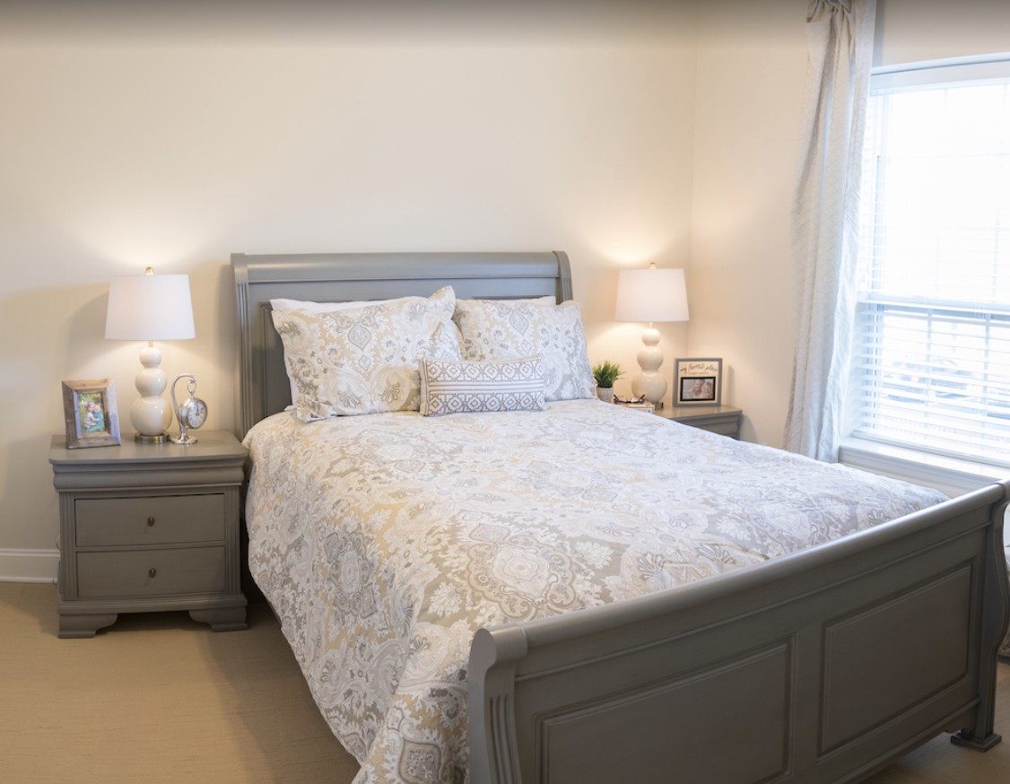 A cozy bedroom with a neatly made bed and matching nightstands, creating a serene and inviting atmosphere.