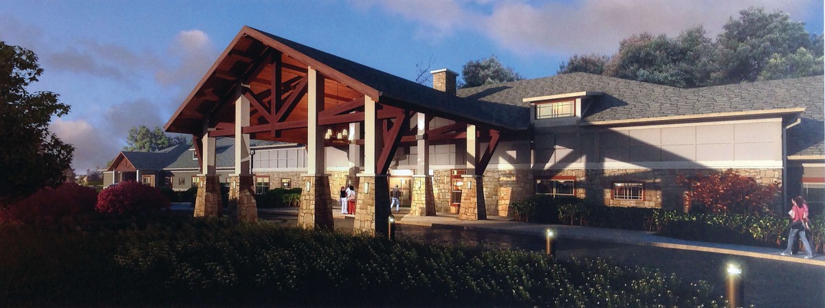 A building entrance with prominent wooden beams and stone columns, captured during the evening.