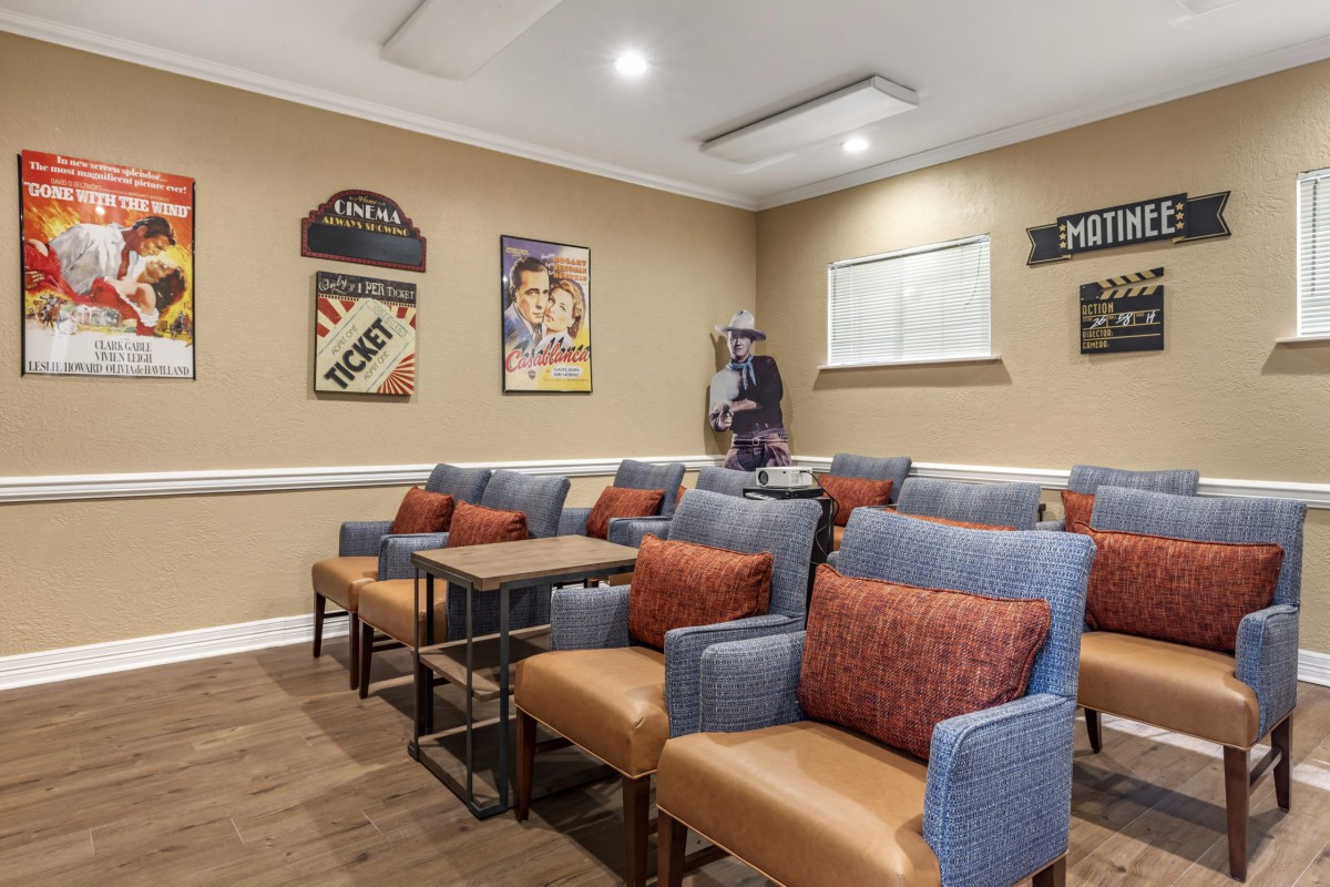 A cozy theater room with comfortable seating and classic movie posters on the wall.