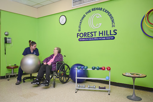 A caregiver assisting an elderly woman in a rehabilitation setting at Forest Hills, promoting health and wellness.