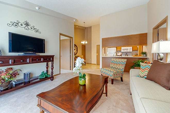 A cozy, well-decorated living room with a sofa, coffee table, and television.