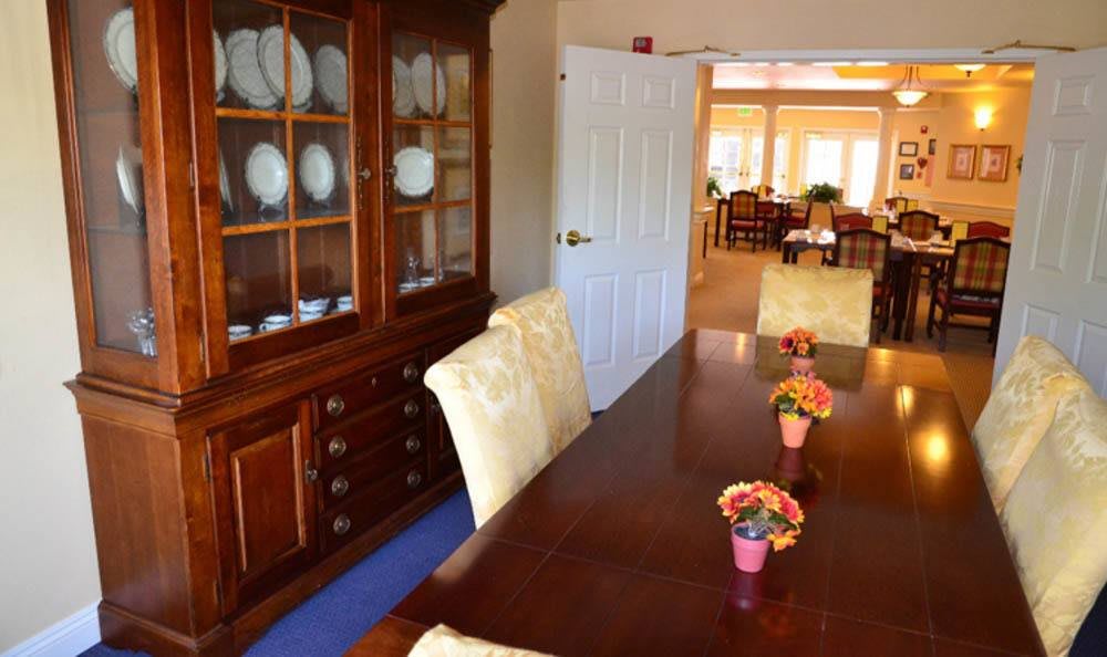 A dining room with a wooden table set, chairs, and a china cabinet.