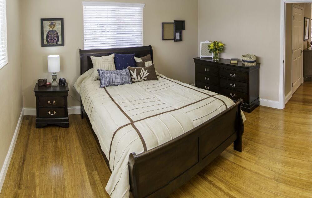 A well-decorated bedroom with a neatly made bed and furnishings.