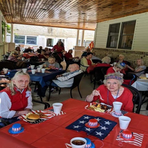 Residents enjoying a festive meal outdoors, adorned in red with patriotic decorations.