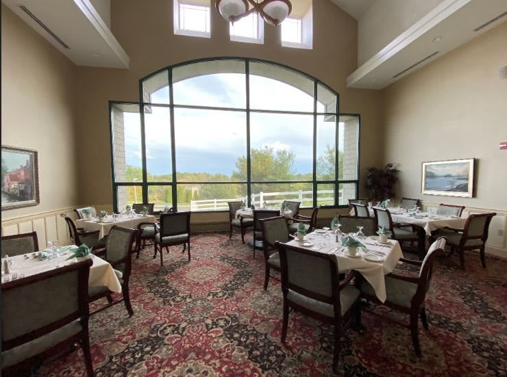 A well-lit restaurant dining area with large windows showcasing a scenic view.