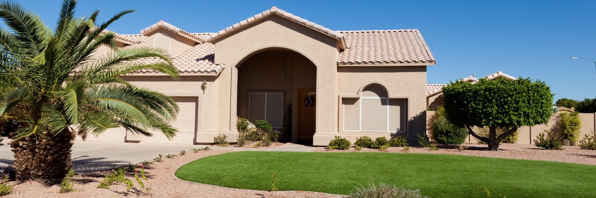 A residential home with a well-maintained front yard and desert landscaping.