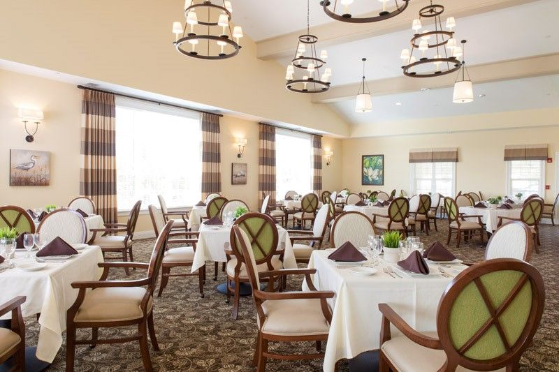 An elegant dining room with neatly arranged tables and stylish chandeliers.