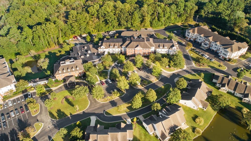 An aerial view of a suburban residential area surrounded by trees.
