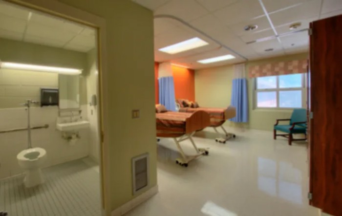 A clean and modern hospital room with medical beds and essential facilities.