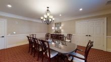 A traditional dining room with a large table and elegant chandelier.