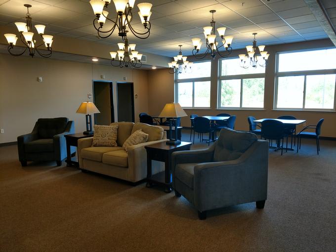 A cozy lounge area with sofas, armchairs, and chandeliers.