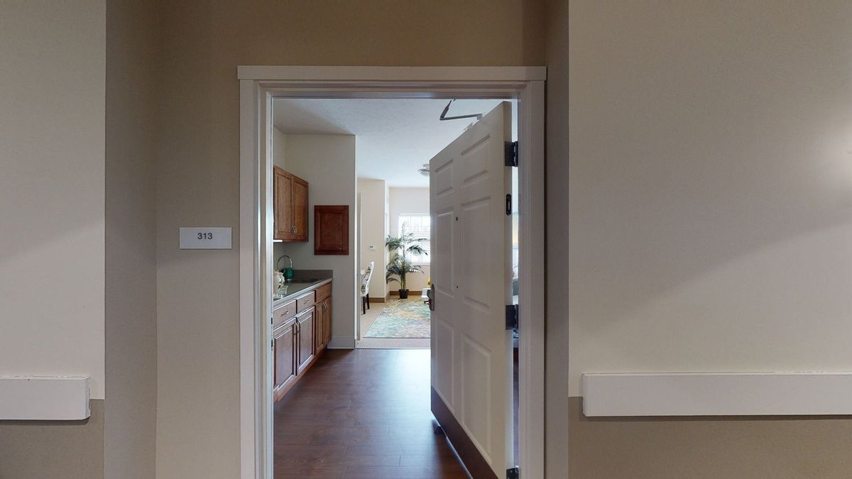 View through a doorway into a kitchen and living area.
