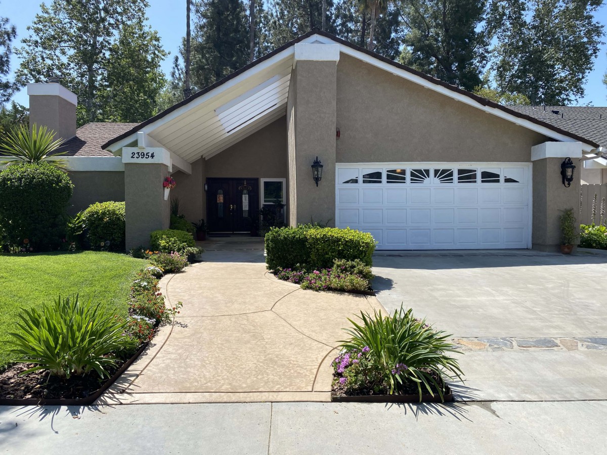 A suburban house with a driveway and landscaped front yard.