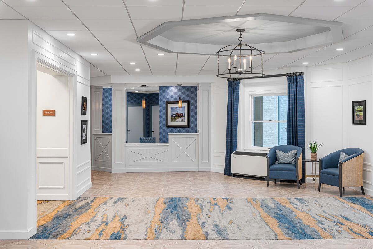 A modern lobby with stylish decor, featuring a chandelier and comfortable seating.