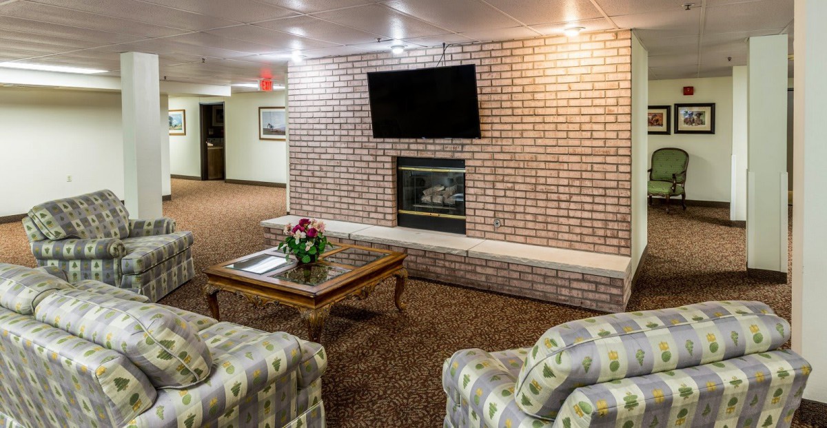 A cozy lobby area with a fireplace, television, and seating arrangements.