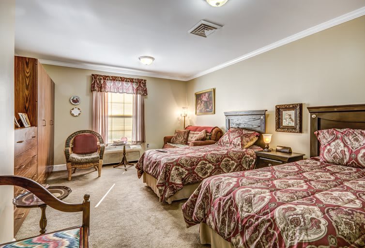 A traditional-style bedroom with two beds and elegant decor.