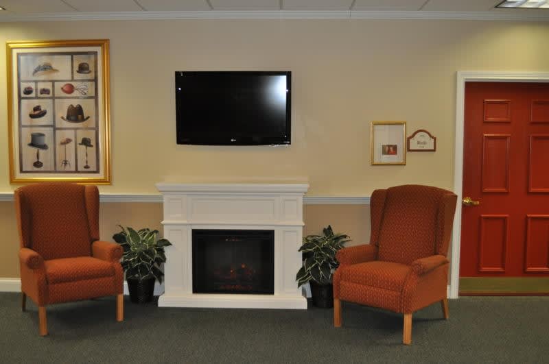 A cozy living room setup with a fireplace, television, and comfortable seating.