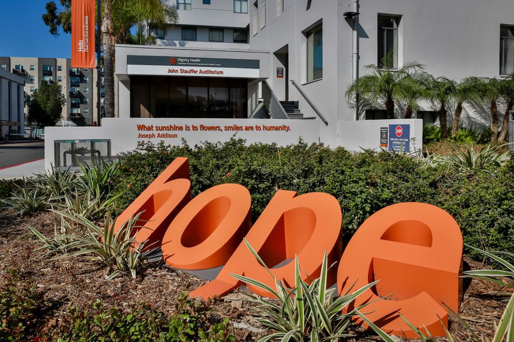 A large 'hope' sign in front of a modern building.