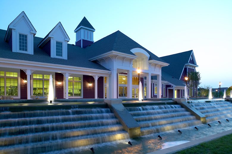 A beautifully lit building with cascading water features at dusk.