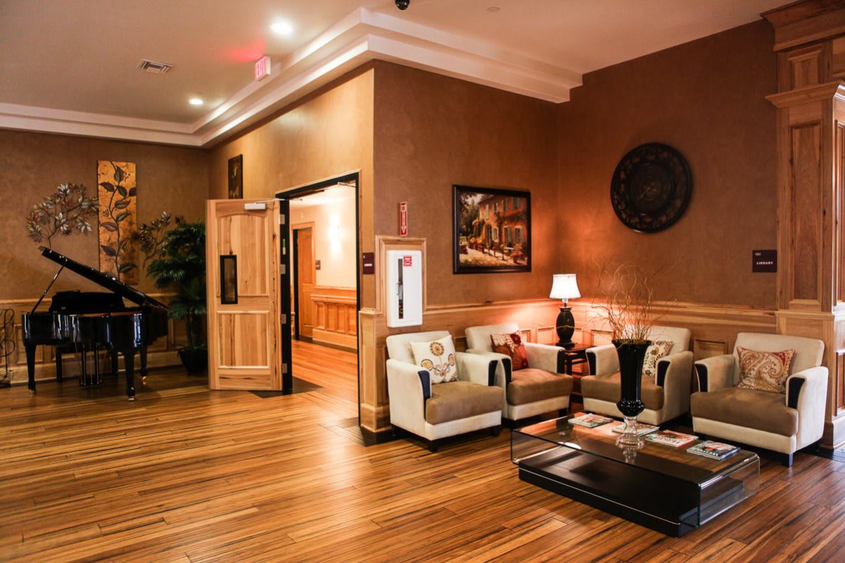 A cozy lounge area with sofas, a lamp, and wooden flooring.