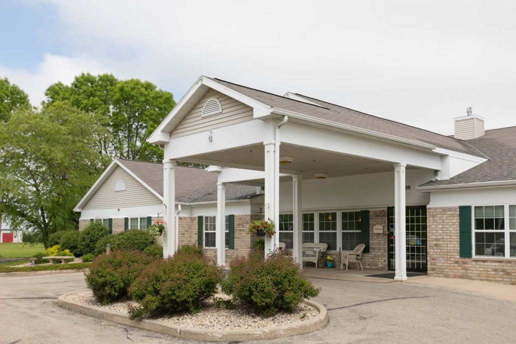 A suburban residential building with a covered entrance and well-maintained landscaping.